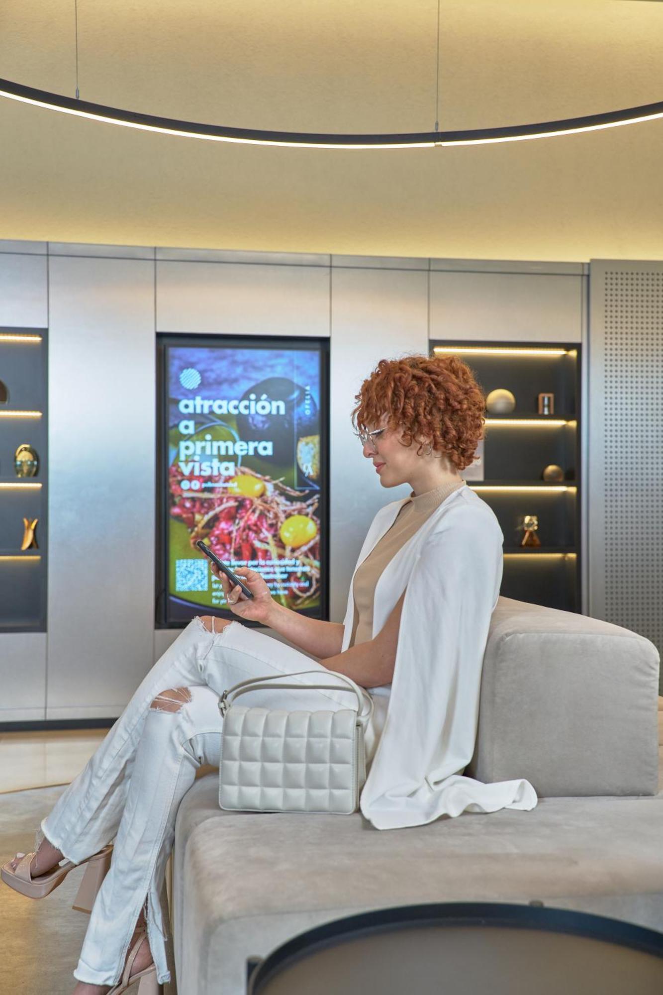 Pullman Santiago Vitacura מראה חיצוני תמונה A woman using a mobile phone to interact with a digital signage display