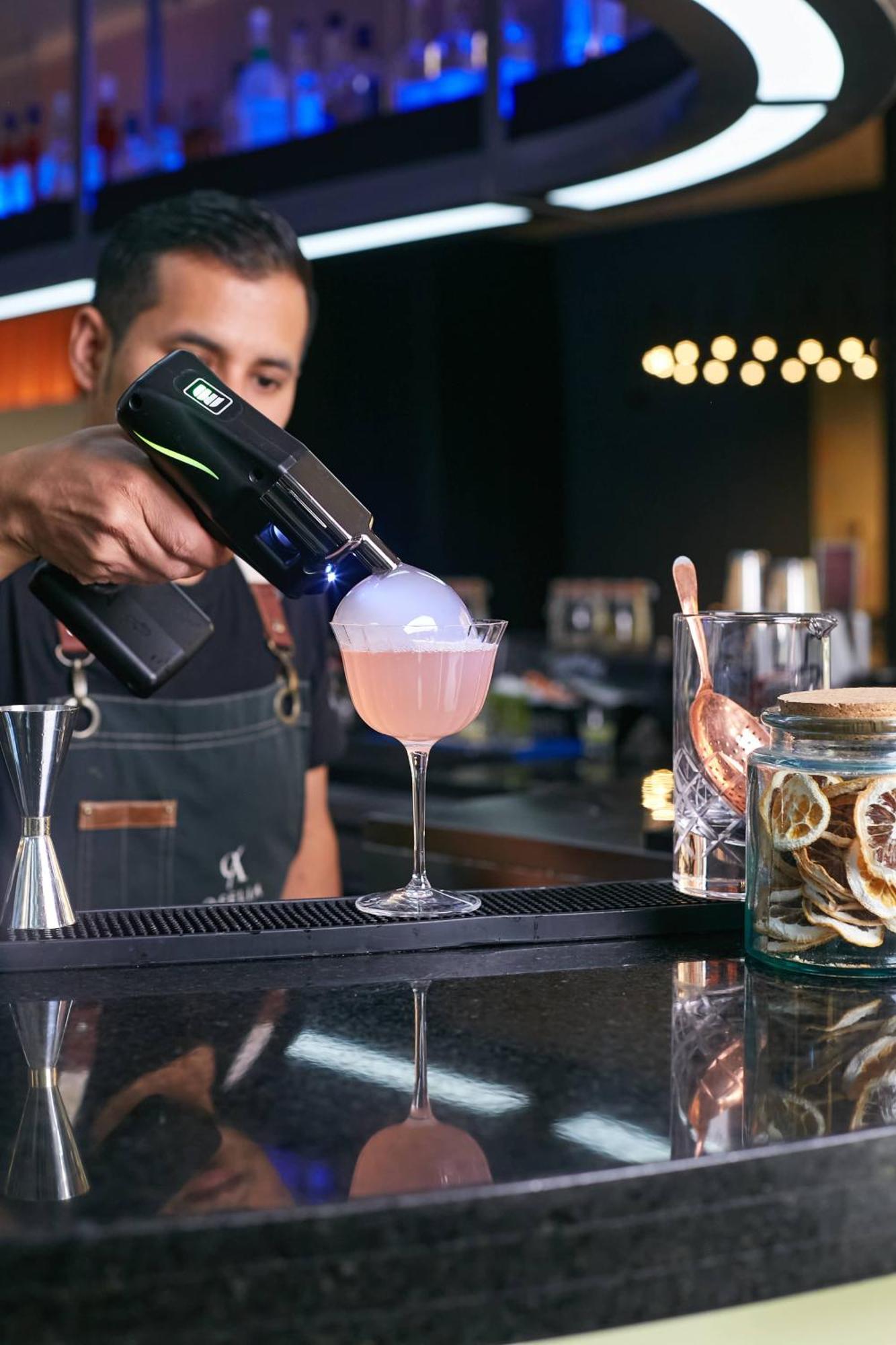 Pullman Santiago Vitacura מראה חיצוני תמונה A bartender using a blowtorch to cook a cocktail